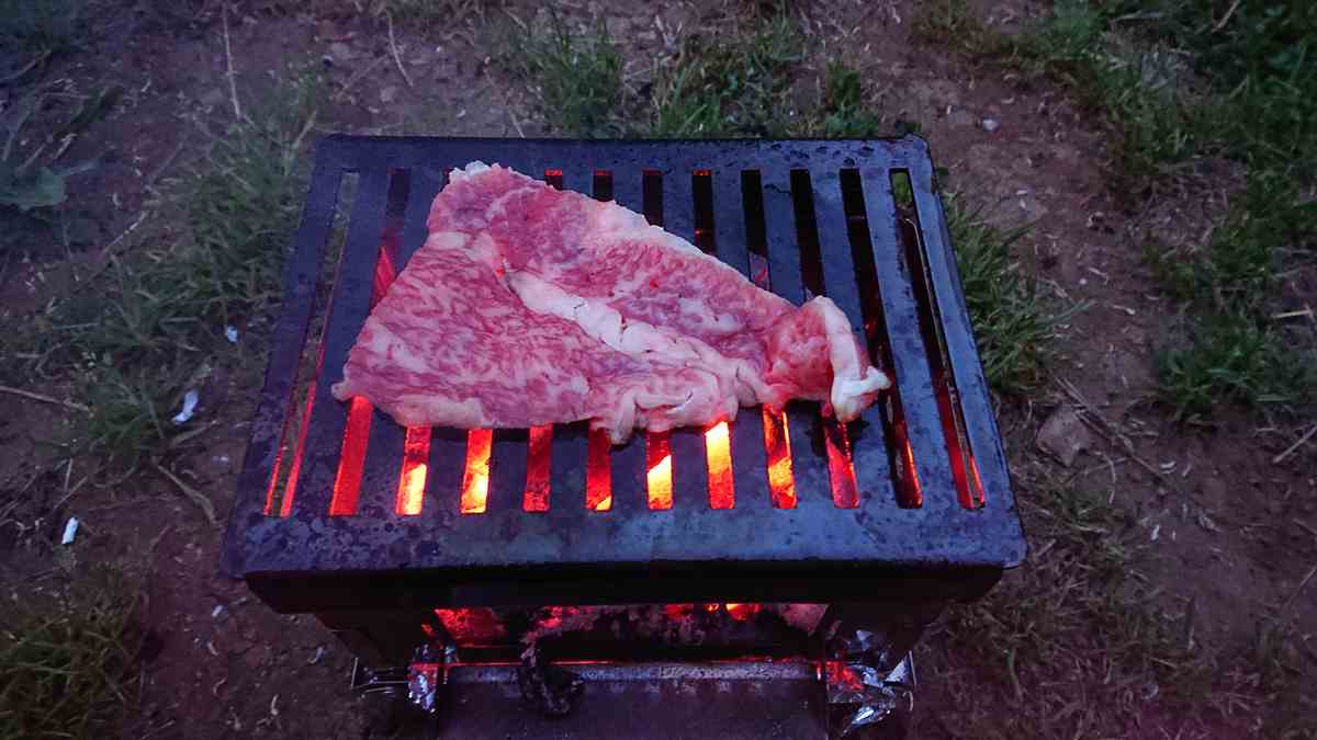 森のまきばオートキャンプ場にて、B-6君という焚火台を使用して和牛上カルビを焼いている様子